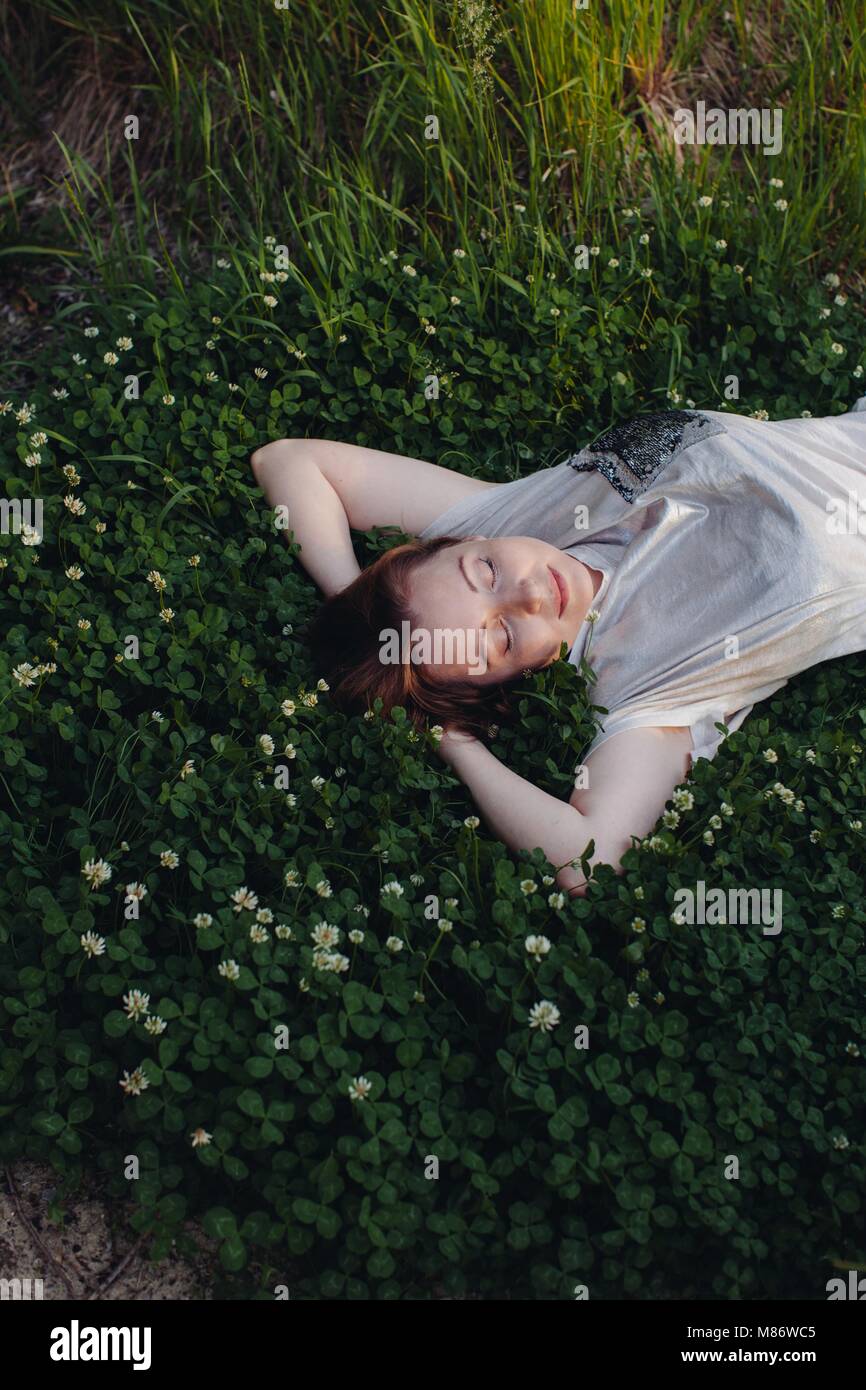 Woman lying on grass relaxing Stock Photo - Alamy