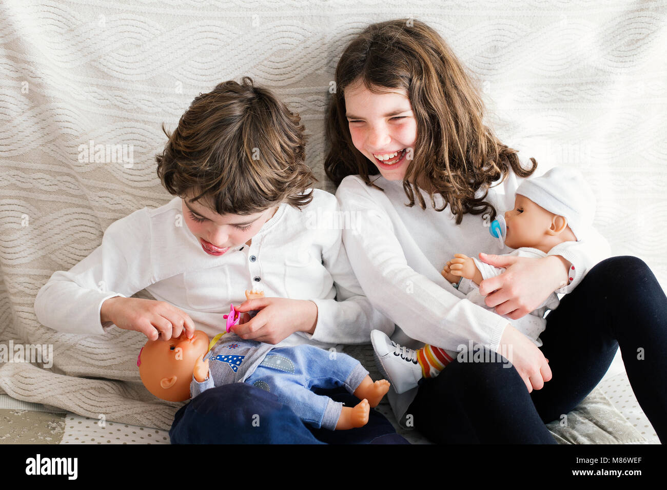 Boy and girl playing with dolls Stock Photo