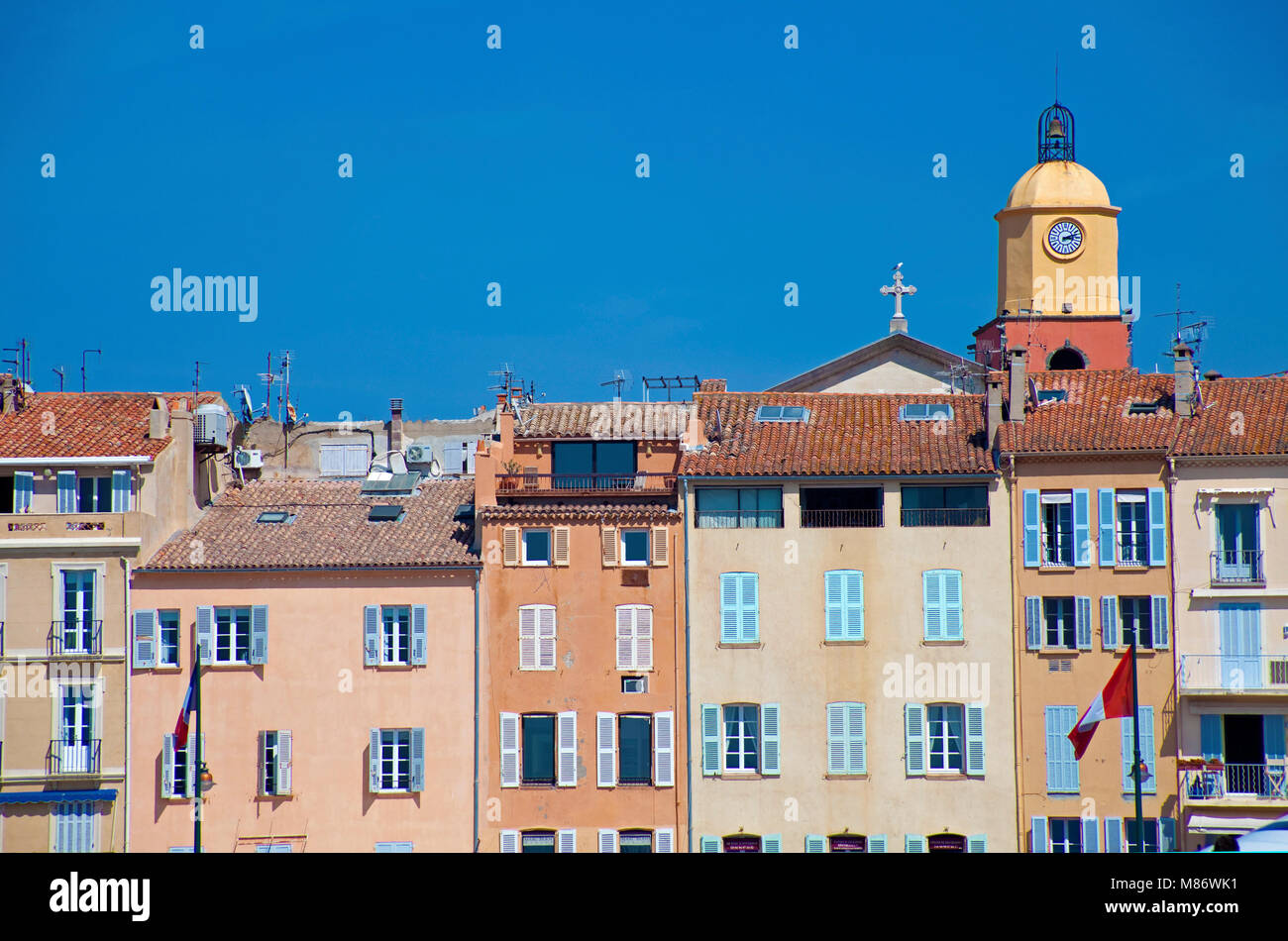 Row of houses and bell tower of Notre-Dame-de-l’Assomption de Saint-Tropez, harbour of Saint-Tropez, french riviera, South France, Cote d'Azur, France Stock Photo
