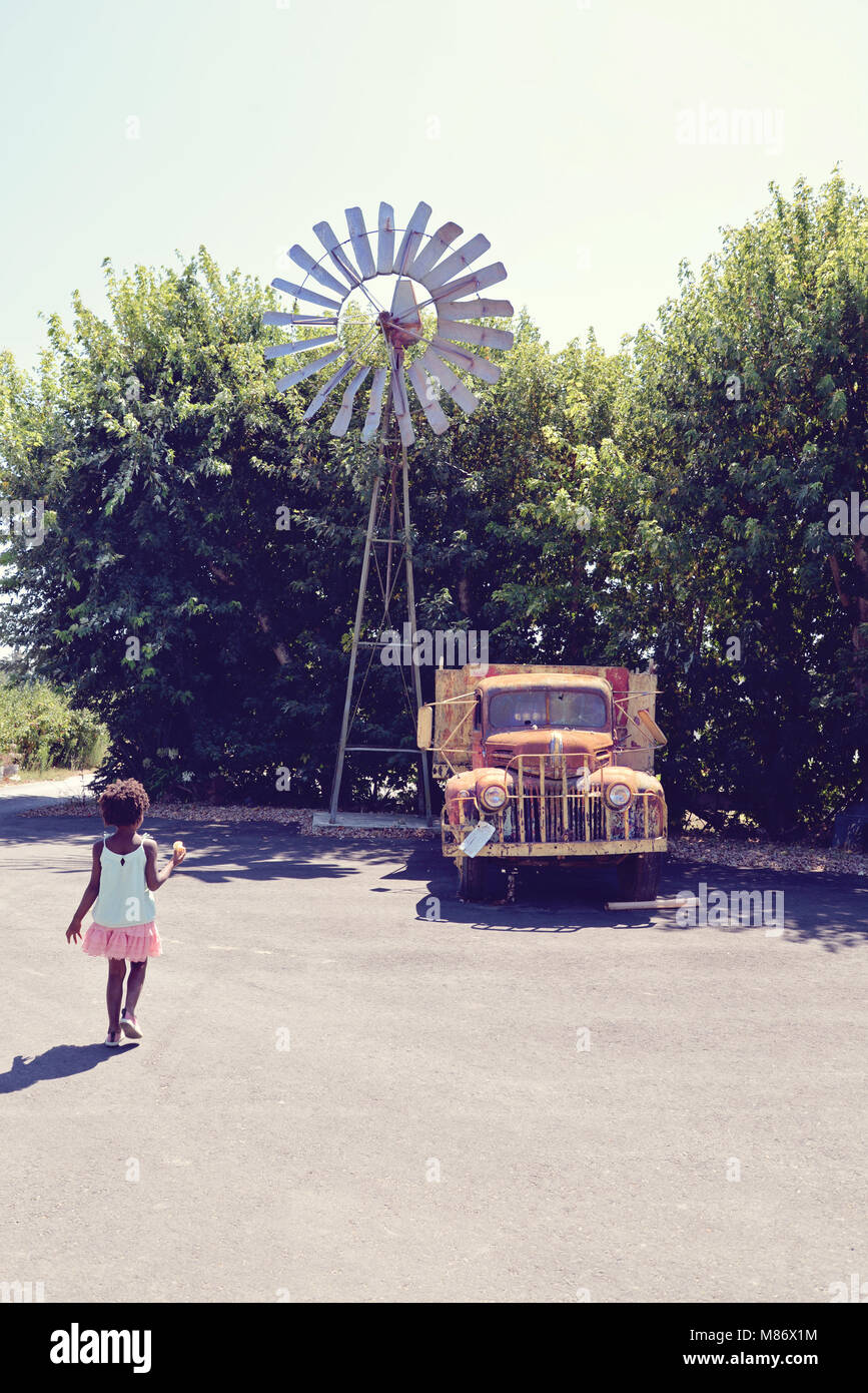 Girl walking towards an old truck Stock Photo