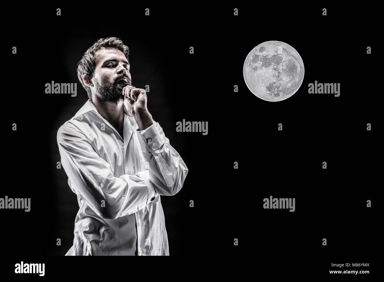 man pensively generates an idea on the background of a full moon Stock Photo