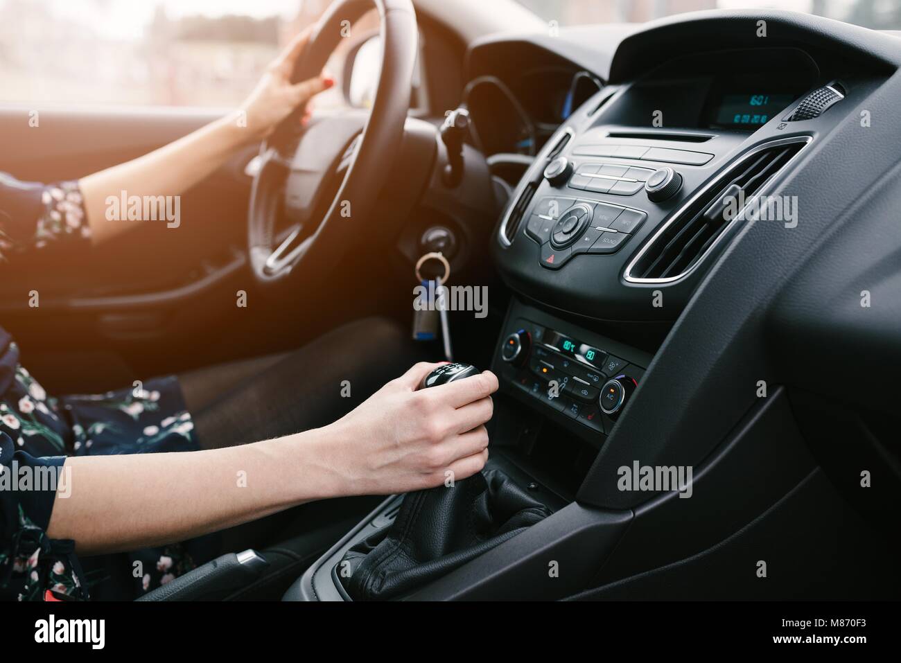 Young woman changing gears in car. Driving a car. Manual transmission. Modern car interior Stock