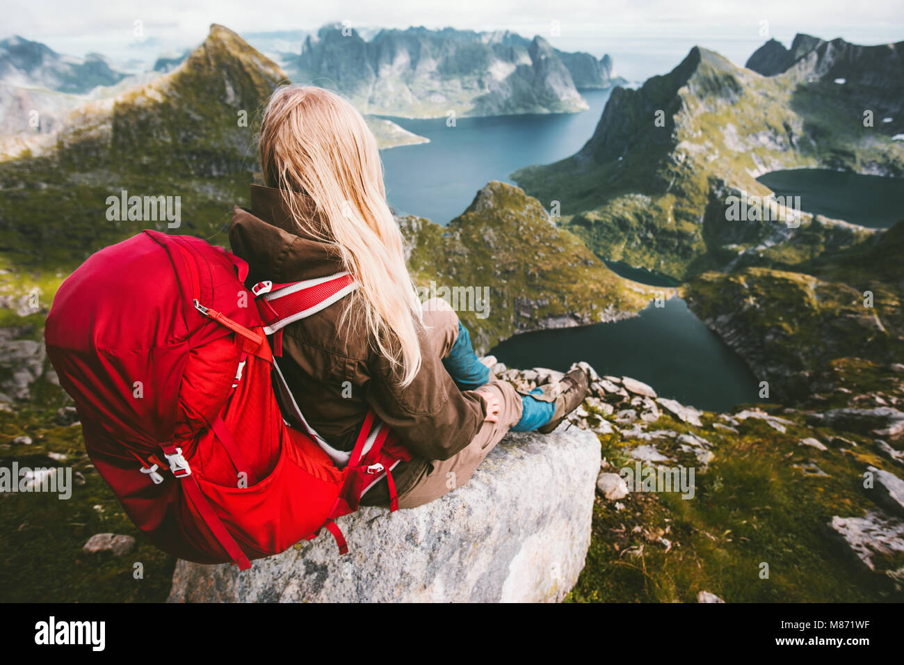 Tourist woman relaxing alone with backpack in mountains Norway Traveling healthy lifestyle adventure concept summer vacations outdoor Stock Photo
