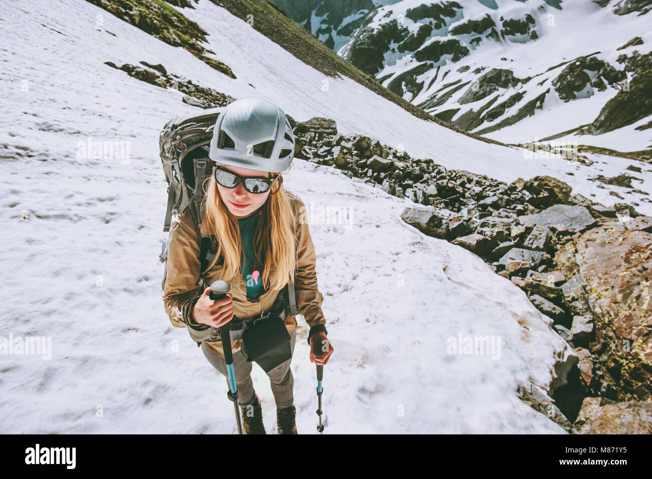 Climber woman hiking in mountains with backpack and helmet gear Traveling lifestyle adventure concept active extreme vacations outdoor Stock Photo
