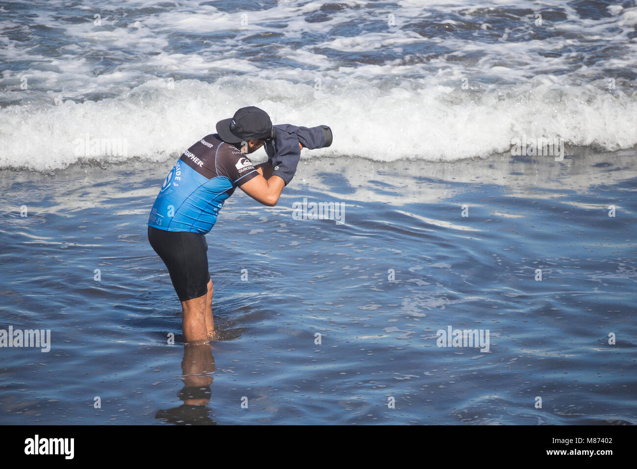 Surf photographer with protective cover on camera and lens Stock Photo