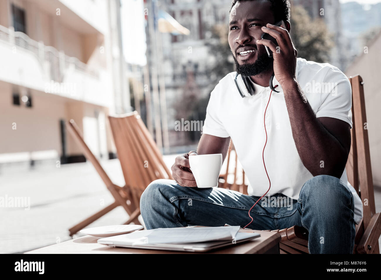 Slightly confused successful man listening to business partner on phone ...