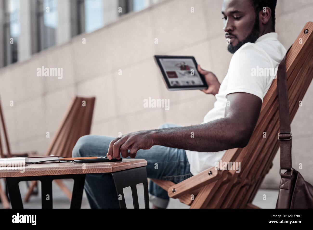 Millennial businessman working on touchpad outdoors Stock Photo