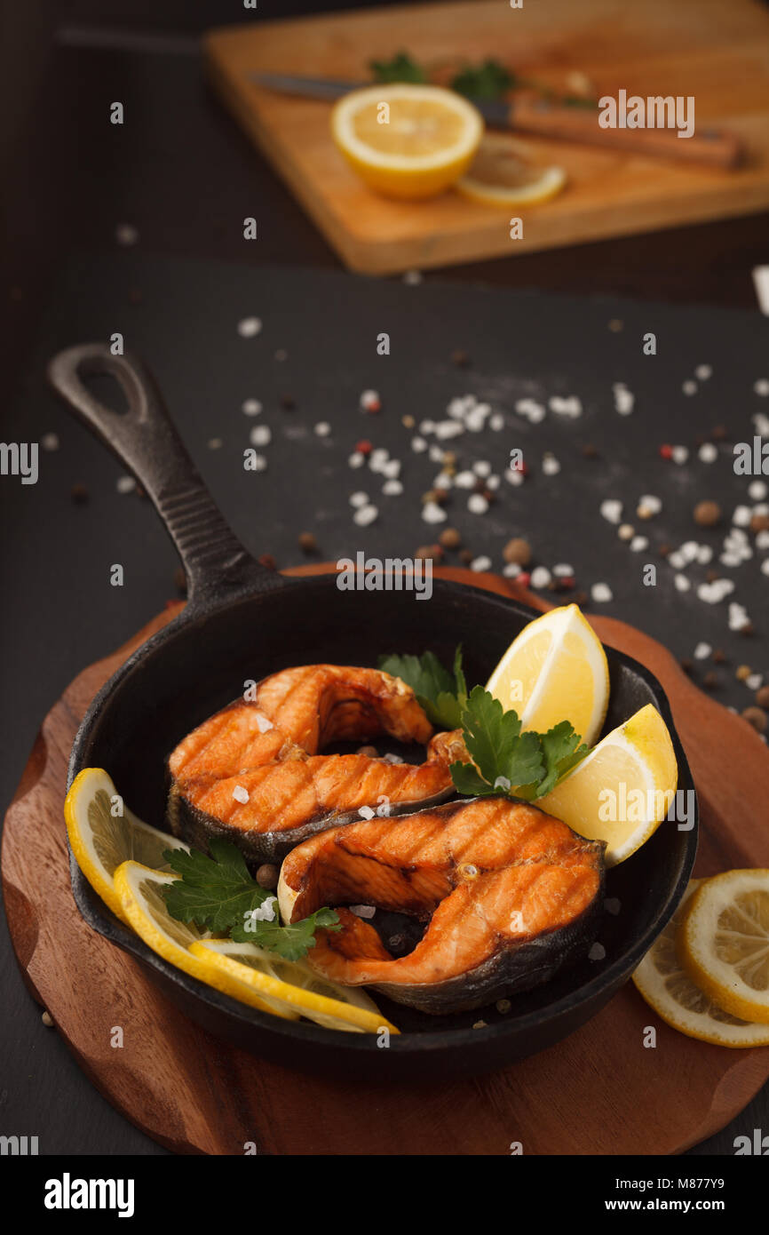 Fried or grilled salmon fillet on castiron pan with lemon Stock Photo