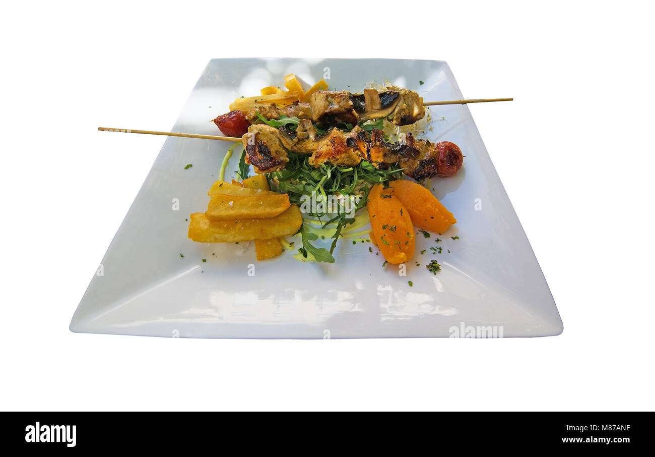 Chicken skewers on white plate delicious meal with vegetables and salad Stock Photo