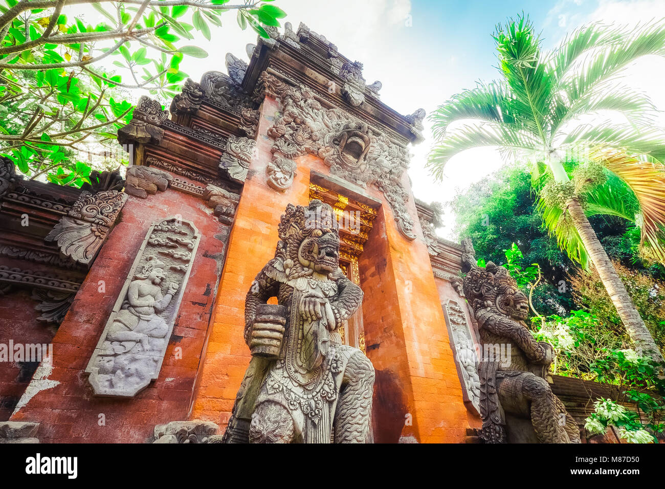 Majestic and tall rock statues Barong Lion Guard near shrine walls lit by sunshine at sunny day