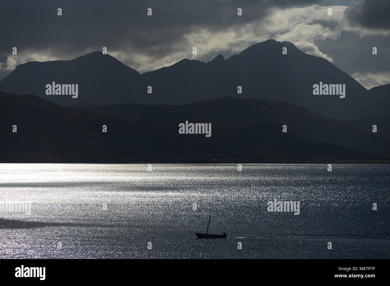 Sailing home. A fishing boat returning home through the Narrows of Raasay with the Cuillin Hills on Skye as a back cloth. Stock Photo