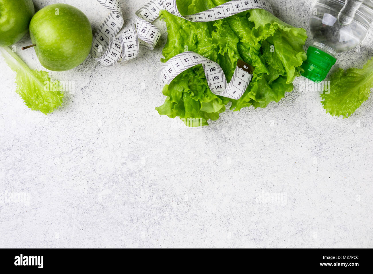 Healthy eating. Green apple, lettuce salad, water bottle, measuring