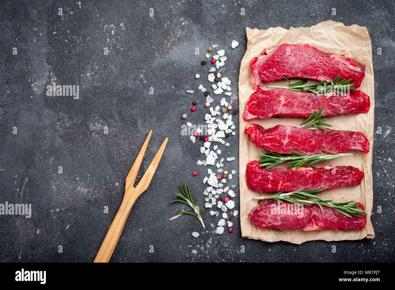 Raw meat on dark background. Raw beef stroganoff with herbs and spices ...