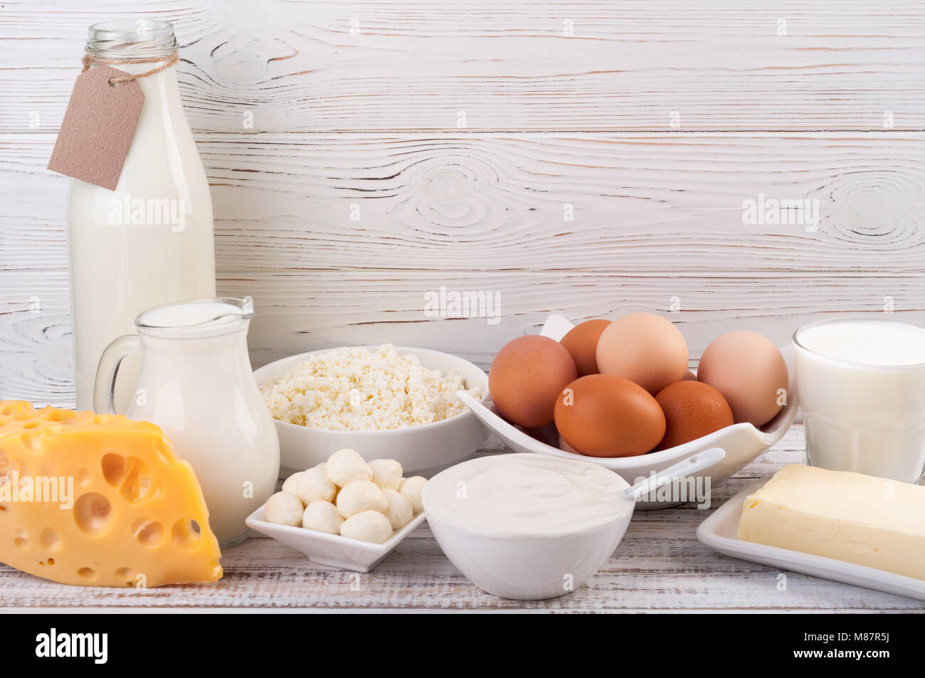 Dairy products on wooden table. Milk, sour cream, cheese, egg, yogurt and butter. Healthy eating and diet concept. Copy space Stock Photo