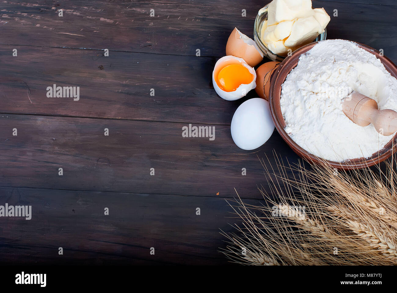 baking background with bake ingredients, ears, egg, flour and butter on