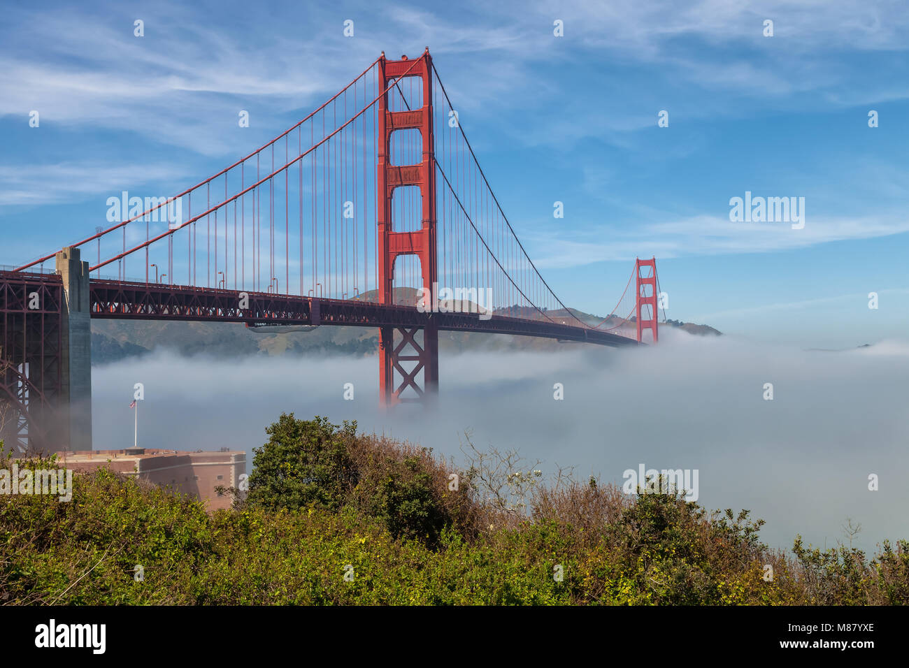 The iconic Golden Gate Bridge, with low fog under the bridge, on an early spring morning, San Francisco, California, United States. Stock Photo