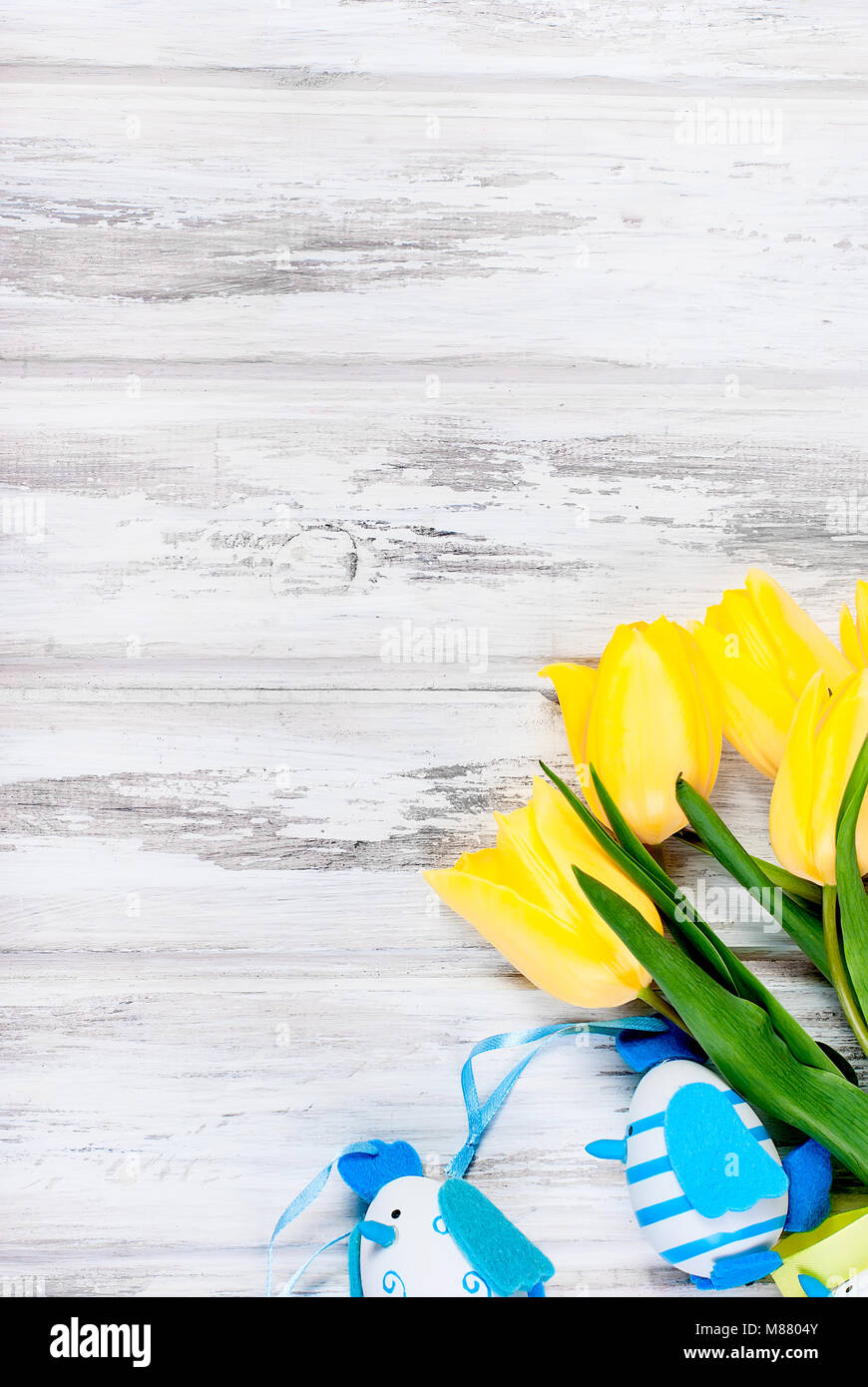 bouquet of yellow tulips and toys chikken easter eggs with a blue ...