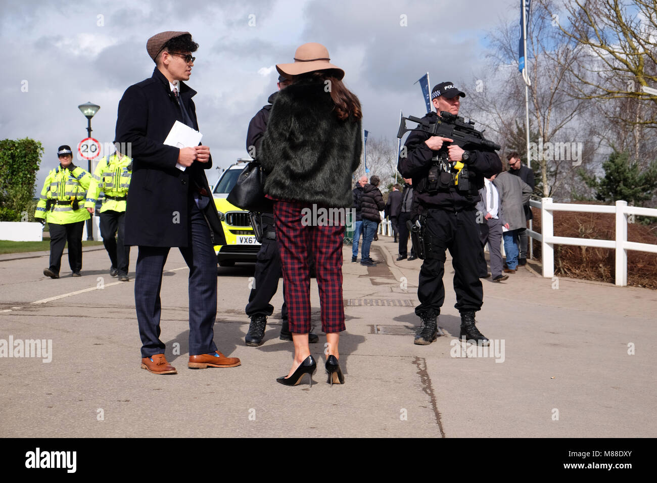 Cheltenham Festival, Gloucestershire, UK - Friday 16th March 2018 - Race goers chat with armed Police officers at the Cheltenham racing festival ahead of this afternoons classic Gold Cup race.  Steven May / Alamy Live News Stock Photo