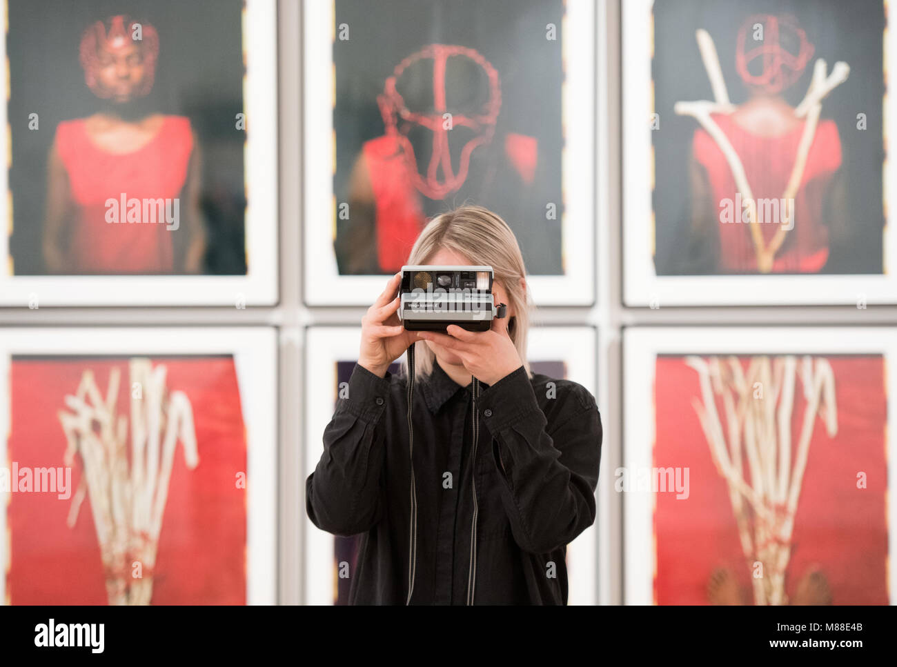 15.03.2018, Hamburg: A woman takes photos in the exhibition "The Polaroid  Project" at the Museum für Kunst und Gewerbe in front of the work "Abridor  de Caminos" (1997) by Maria Magdalena Campos-Pons