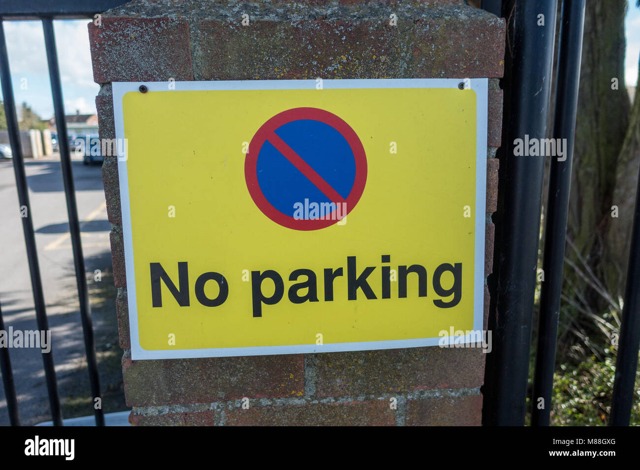 A no parking sign attached to a brick pillar. Stock Photo