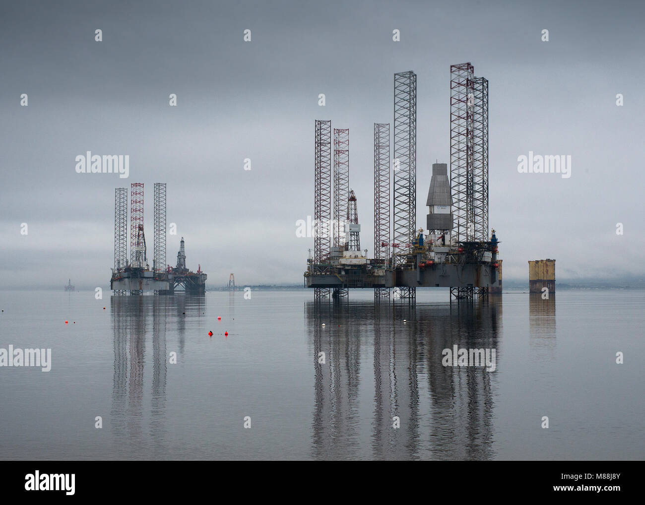 Oil rigs drilling platforms moored in Cromarty Firth viewed from town of Cromarty on the Black Isle in Ross & Cromarty, Highland Region, Scotland Stock Photo