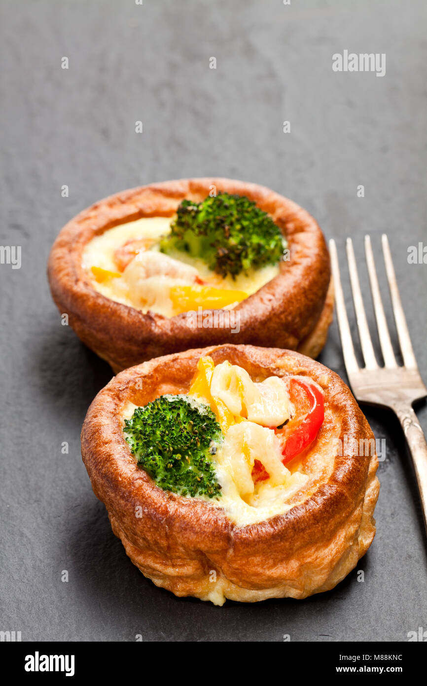 Yorkshire  puddings stuffed with broccoli and scrambled eggs on black stone background Stock Photo