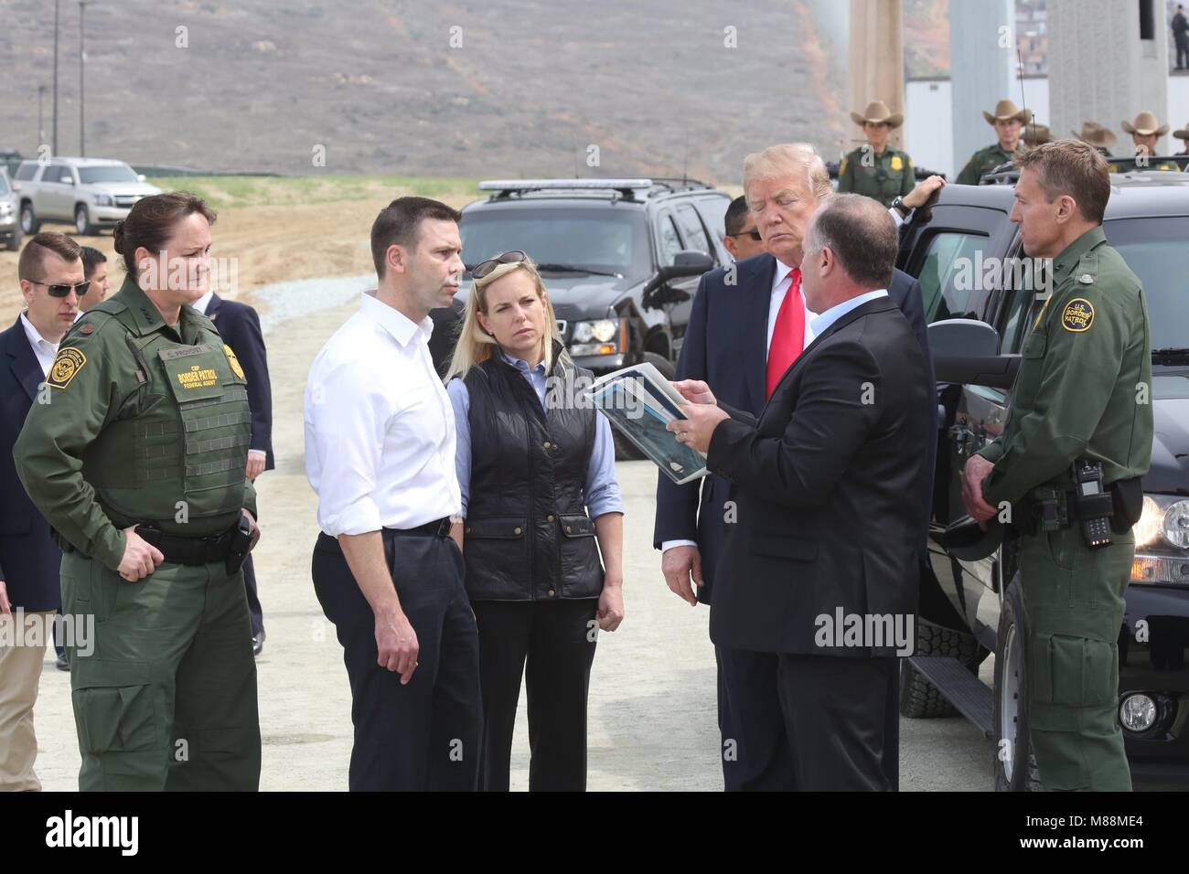 U.S President Donald Trump is show prototypes of the proposed border wall by site Manager Jim O'Loughlin, right, as Acting CBP Commissioner Kevin McAleenan and Homeland Secretary Kirstjen Nielsen look on at the Otay Mesa Port of Entry March 13, 2018 in San Diego, California. Stock Photo