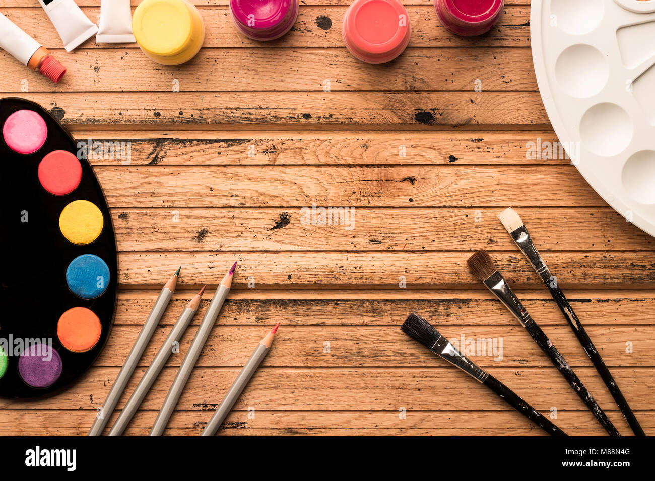 Ready to paint. Artistic materials watercolors and brushes on a wooden