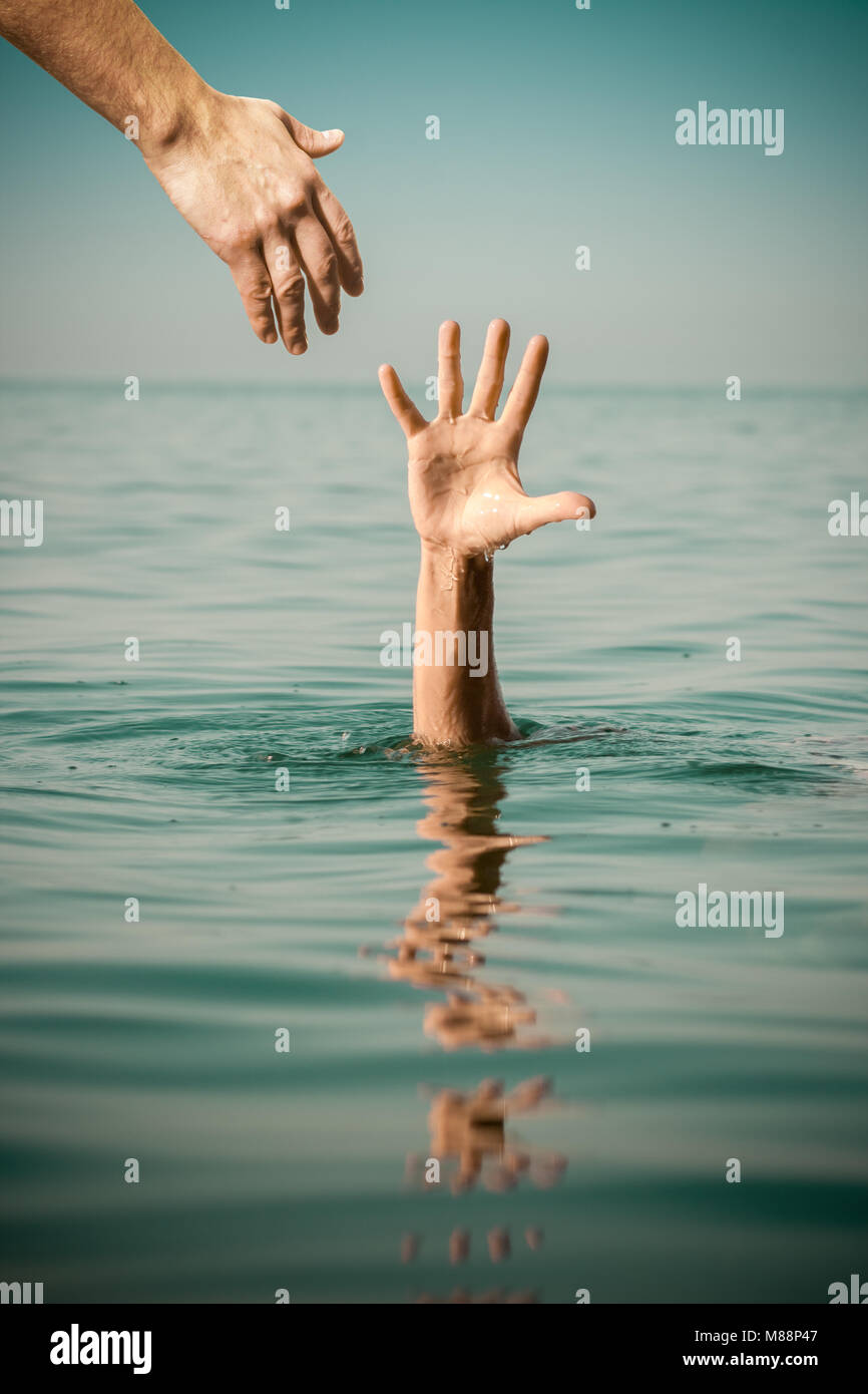 hand of help for drowning man life saving in sea water Stock Photo