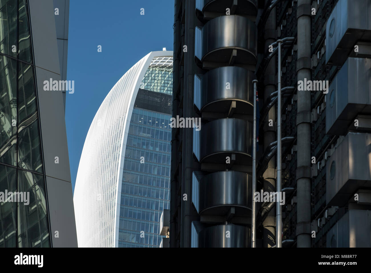 The Walkie Talkie Building seen through a gao between Lloyds of London and Willis Towers Watson on a clear summer day Stock Photo