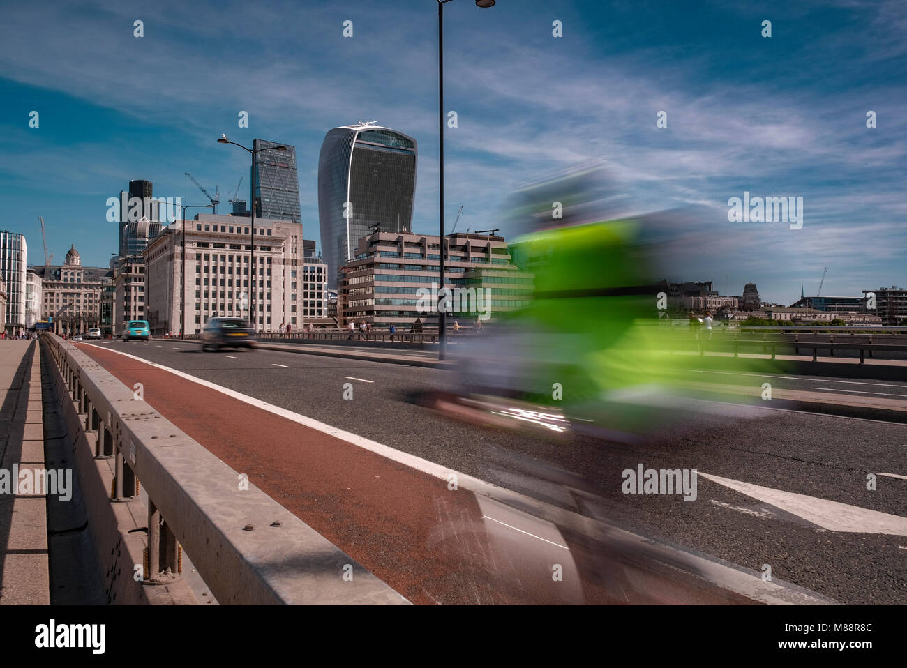 Motion of a cyclist as they speed across London Bridge towards The City on a Summers Morning Stock Photo