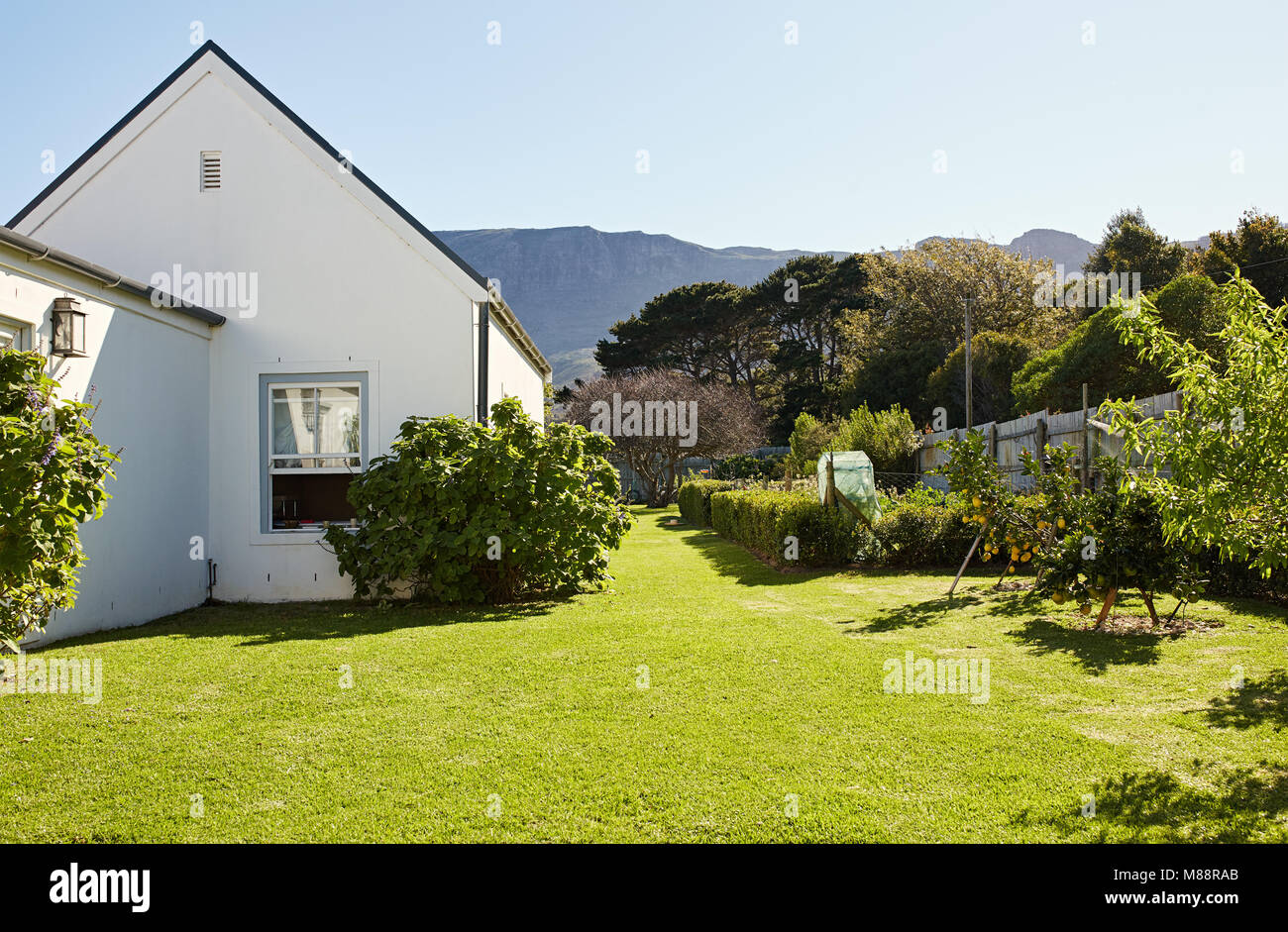 Exterior of the large grassy backyard and back of a residential home in the country on a sunny day Stock Photo