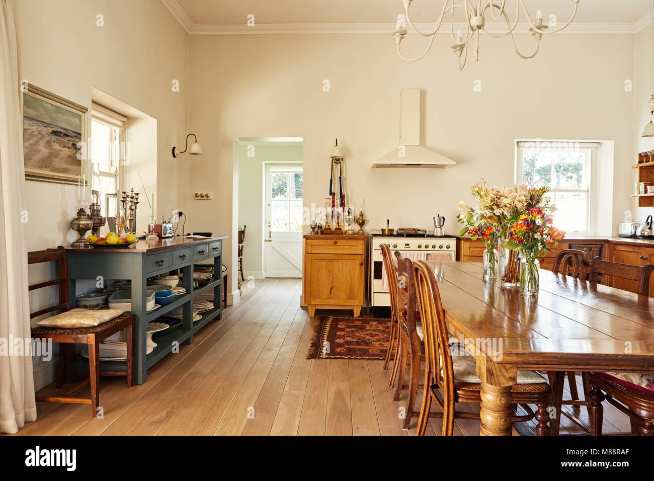Interior of a large country style kitchen in a residental home with a wooden dining table and appliances Stock Photo