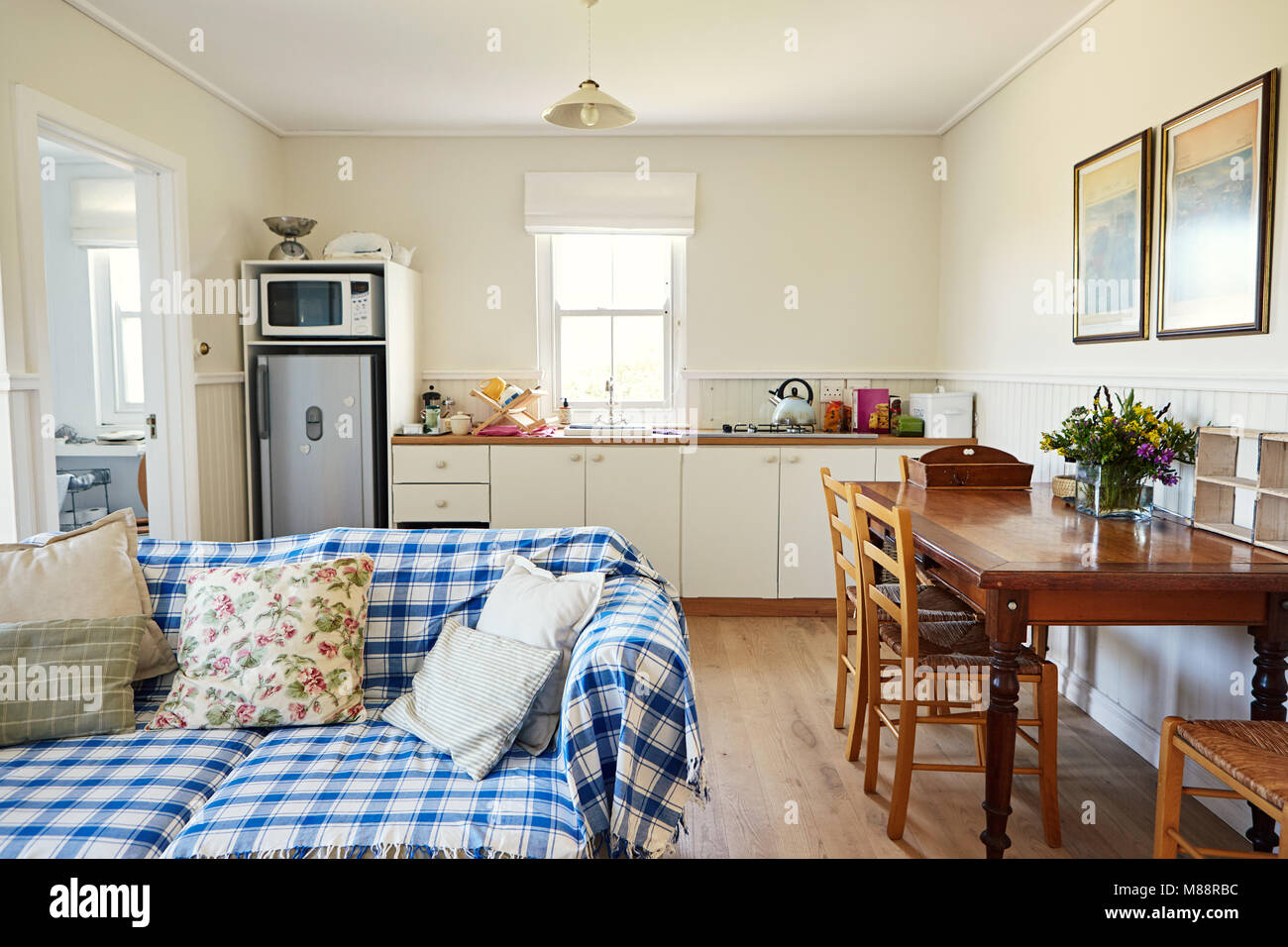 Interior of a lounge with a small kitchen in the background of a country style residential home Stock Photo