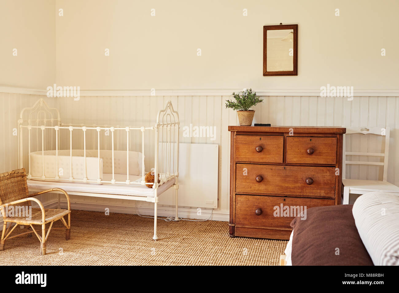 Interior of a bright master bedroom with a bed and baby's cot in a contemporary residential home Stock Photo