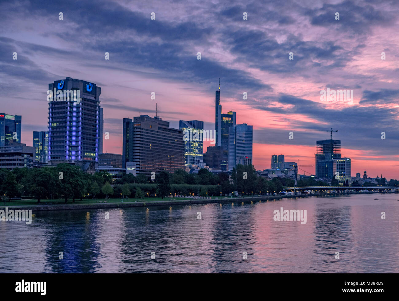 The skyline of Frankfurt business district at dawn seen from Friedensbrücke. The River Main is in the foreground Stock Photo
