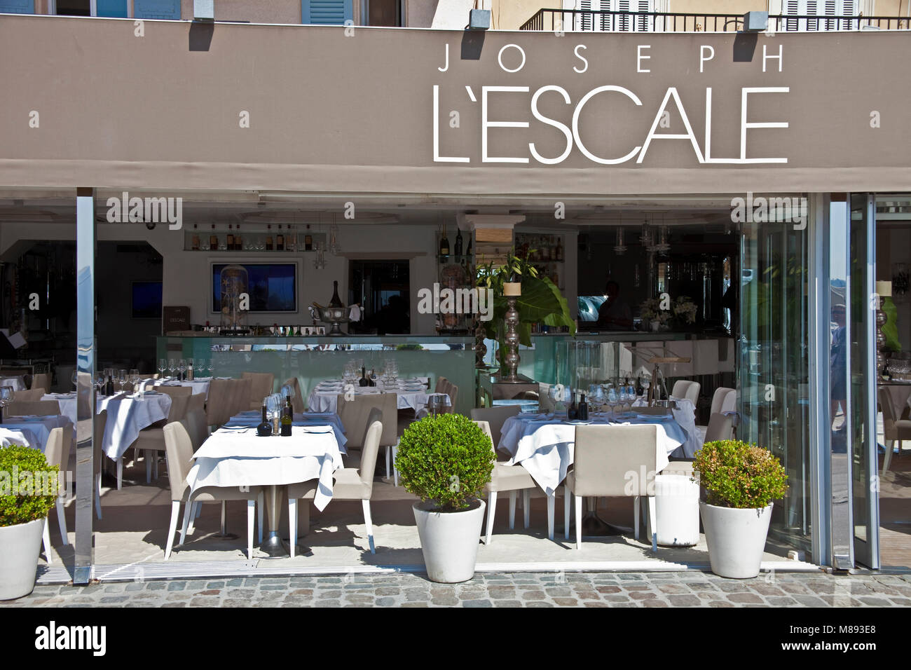 Laid tables at restaurant Joseph L'Escale at at harbour promenade of Saint-Tropez, french riviera, South France, Cote d'Azur, France, Europe Stock Photo