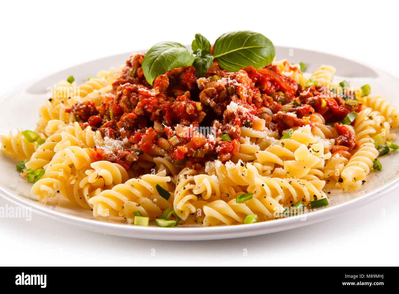 Pasta with meat, tomato sauce and vegetables on white background Stock Photo