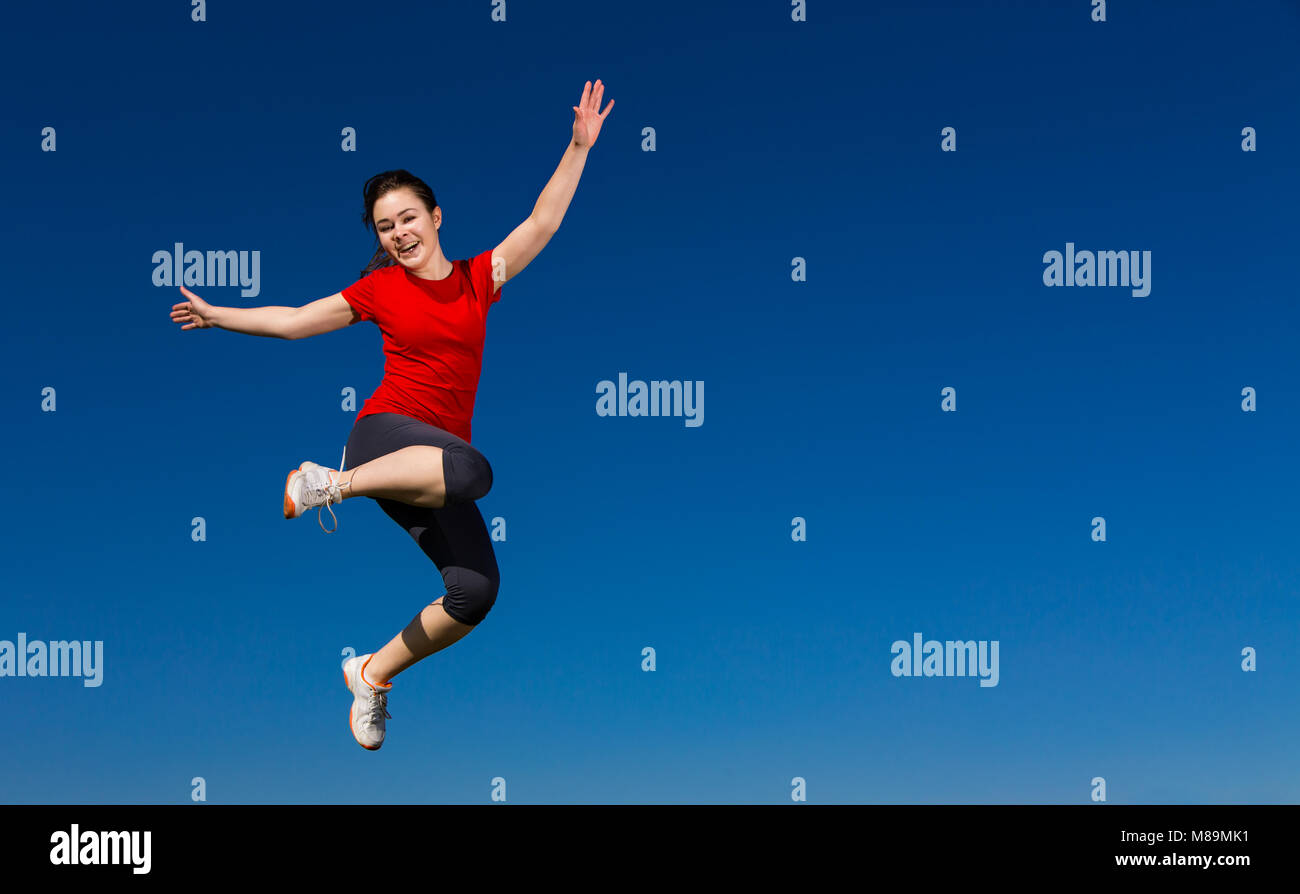 Teenage girl jumping outdoor against blue sky Stock Photo - Alamy