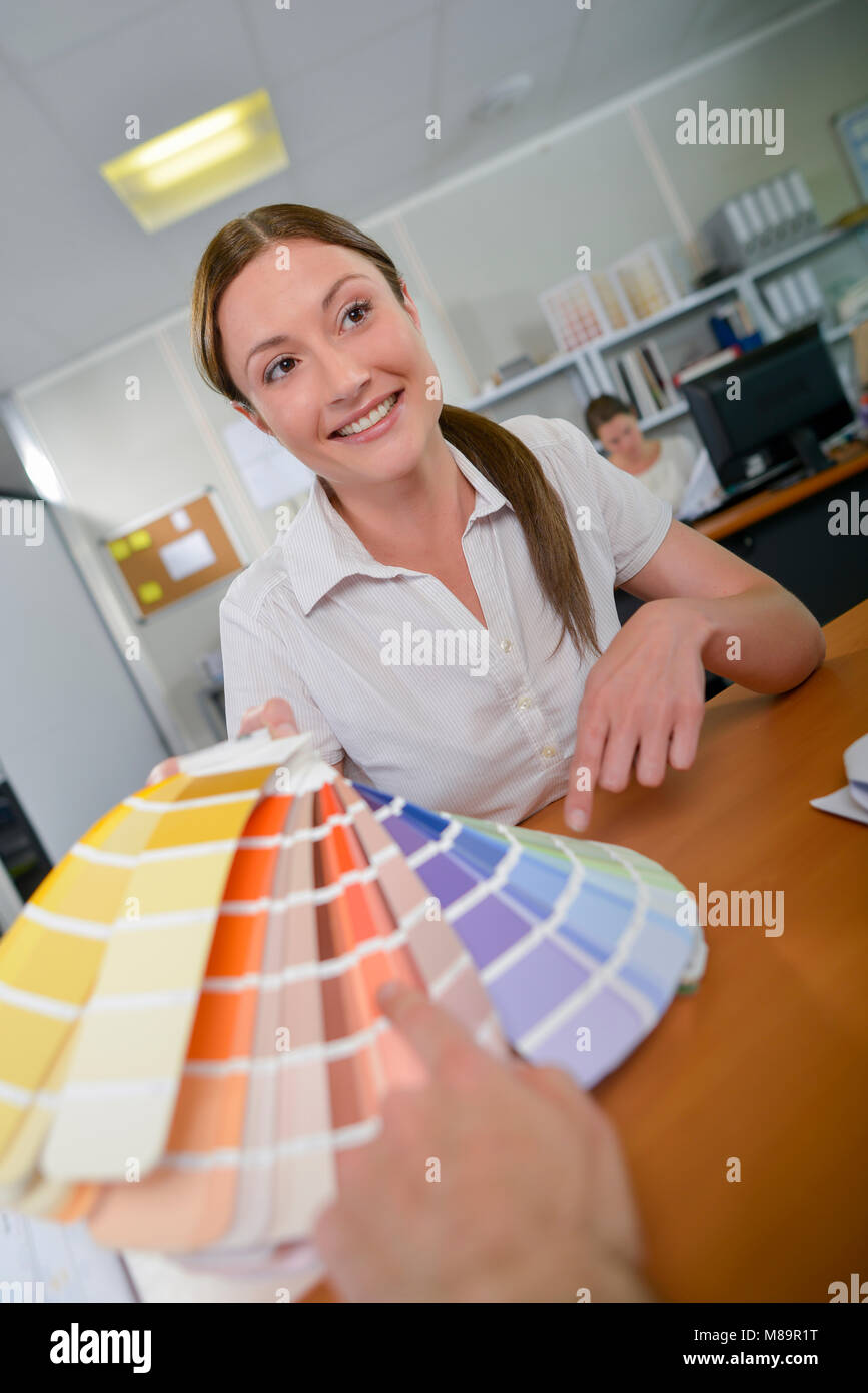 Lady showing color charts to client Stock Photo - Alamy