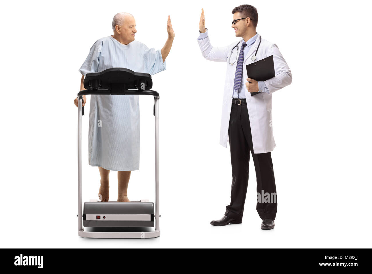 Full length profile shot of an elderly patient walking on a treadmill and high-fiving a doctor isolated on white background Stock Photo