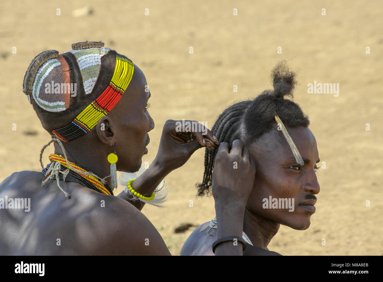 Daasanach tribe village the male elders sit around idle. Africa, Ethiopia, Omo Valley, Stock Photo
