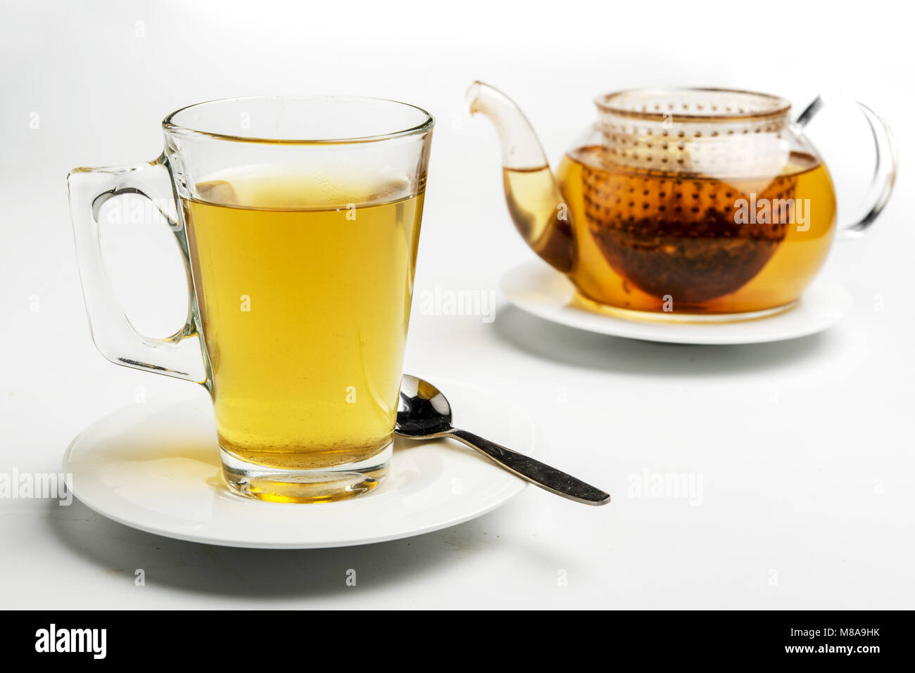 Glass of tea and teapot. The Tea bag can be seen in the pot Stock Photo