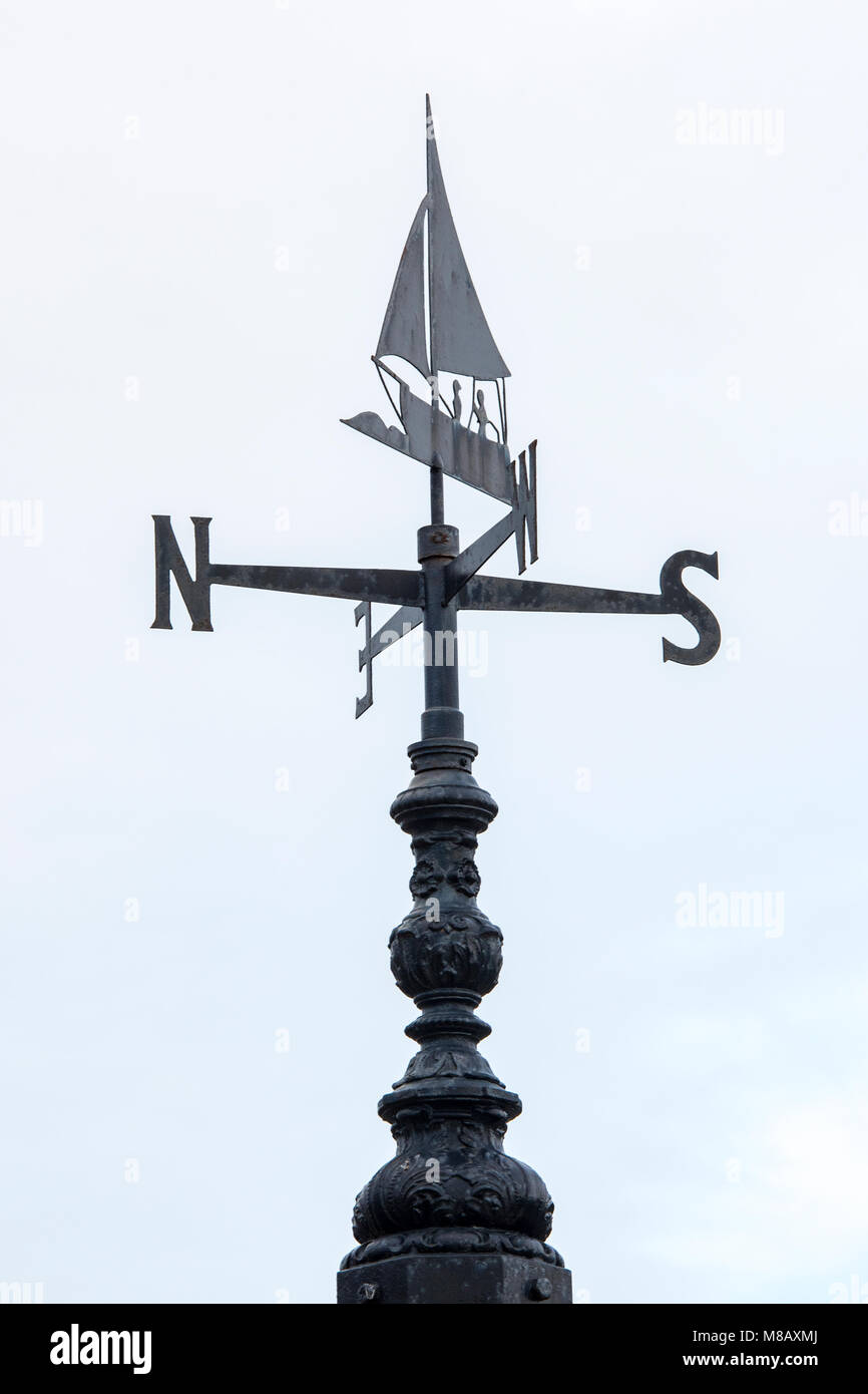 A nautical style or themed weather vane with a dinghy or yacht design
