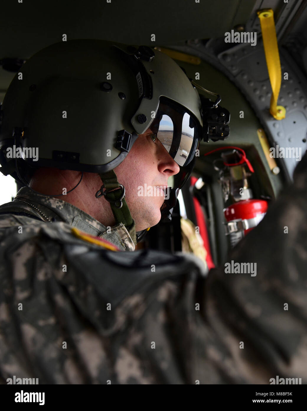 A U.S. Army crew chief with the 1-135th Assault Helicopter Battalion looks out a window of a UH-60 Black Hawk during a joint training mission at Whiteman Air Force Base, Mo., Jan. 31, 2018. In addition to establishing a partnership, the purpose of the training was to familiarize Joint Terminal Attack Controllers from the 7th Air Support Operations Squadron, located in Fort Bliss, Texas, with the assets available at Whiteman AFB that are used in a multi-domain fight. (U.S. Air Force Stock Photo