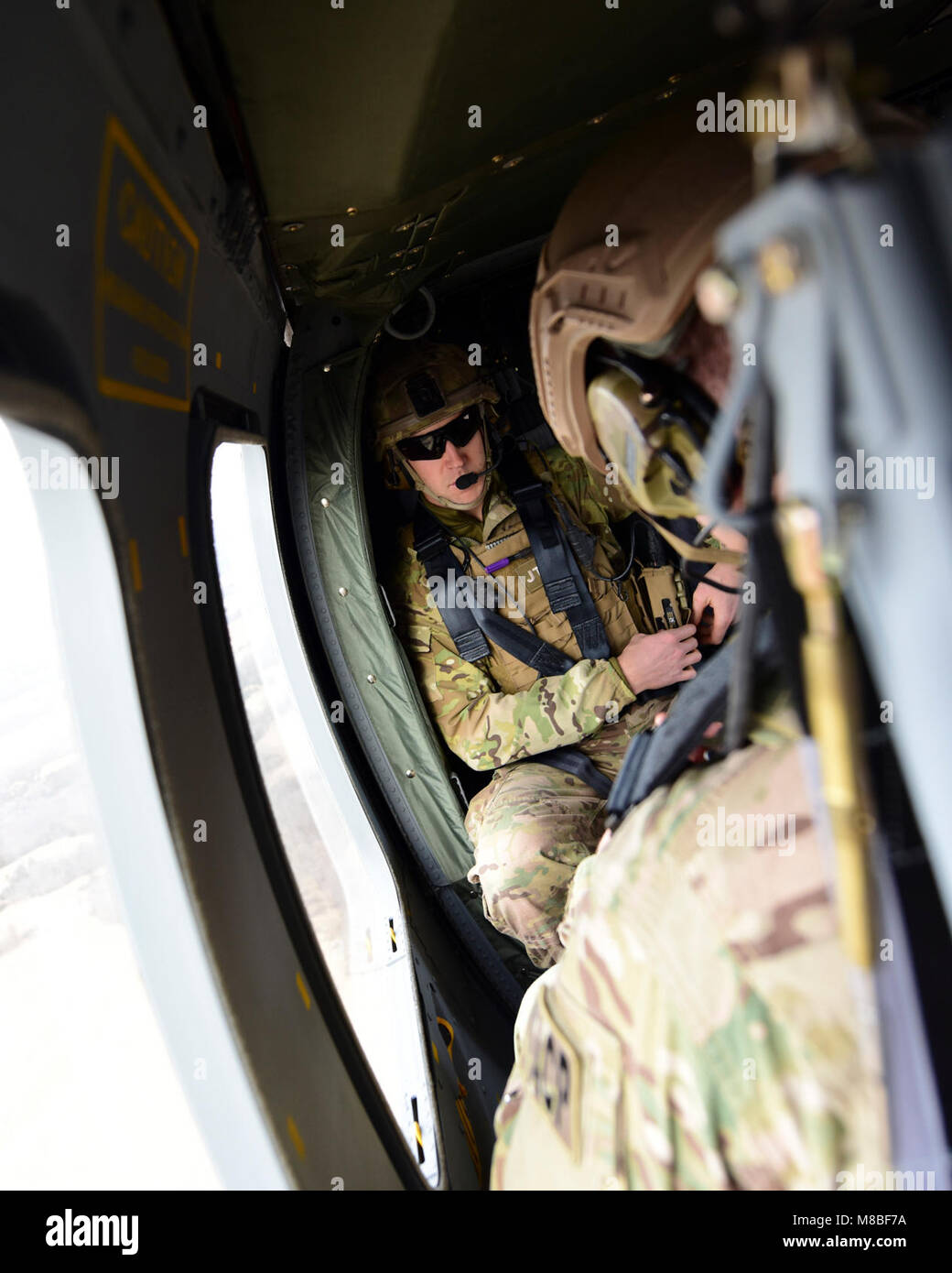 A Joint Terminal Attack Controller rides in a UH-0 Black Hawk during a joint training at Warshaw, Mo., Jan. 31, 2018. This training allowed JTAC to work with to work together units from Whiteman Air Force Base, Mo., to help standardize how JTACs are integrated into a multi-domain fight. (U.S. Air Force by Staff Sgt. Danielle Quilla) Stock Photo
