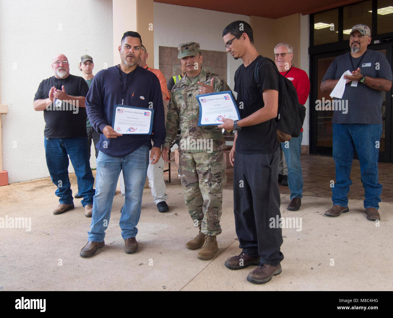 SAN JUAN, PUERTO RICO— Lt. Col. Roberto Solorzano, the commander of the U.S. Army Corps of Engineers Recovery Field Office in Puerto Rico, presented certificates of appreciation to Hector Jimenez and Jose Ruiz for their support in bringing electrical power to the people of Puerto Rico. Part of the temporary power mission, quality assurance teams inspect more than 500 installed generators daily to ensure functionality and to identify maintenance needs. Stock Photo