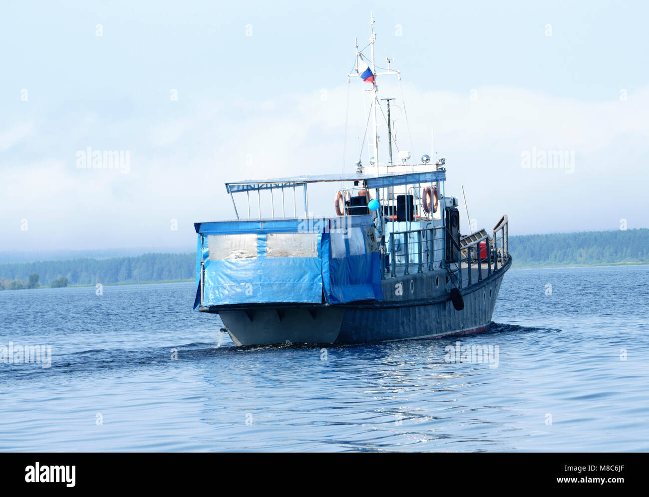 tugboat pushes sand debris along the river Stock Photo