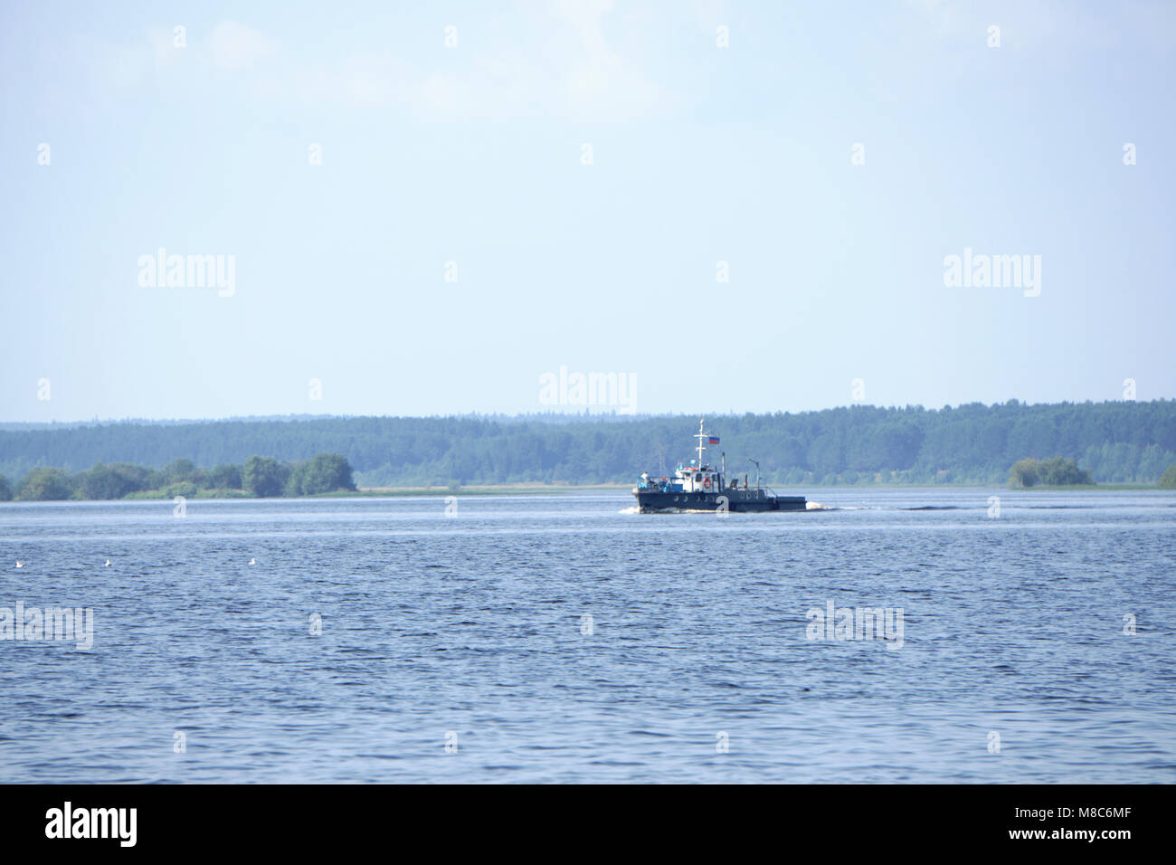 tugboat pushes sand debris along the river Stock Photo