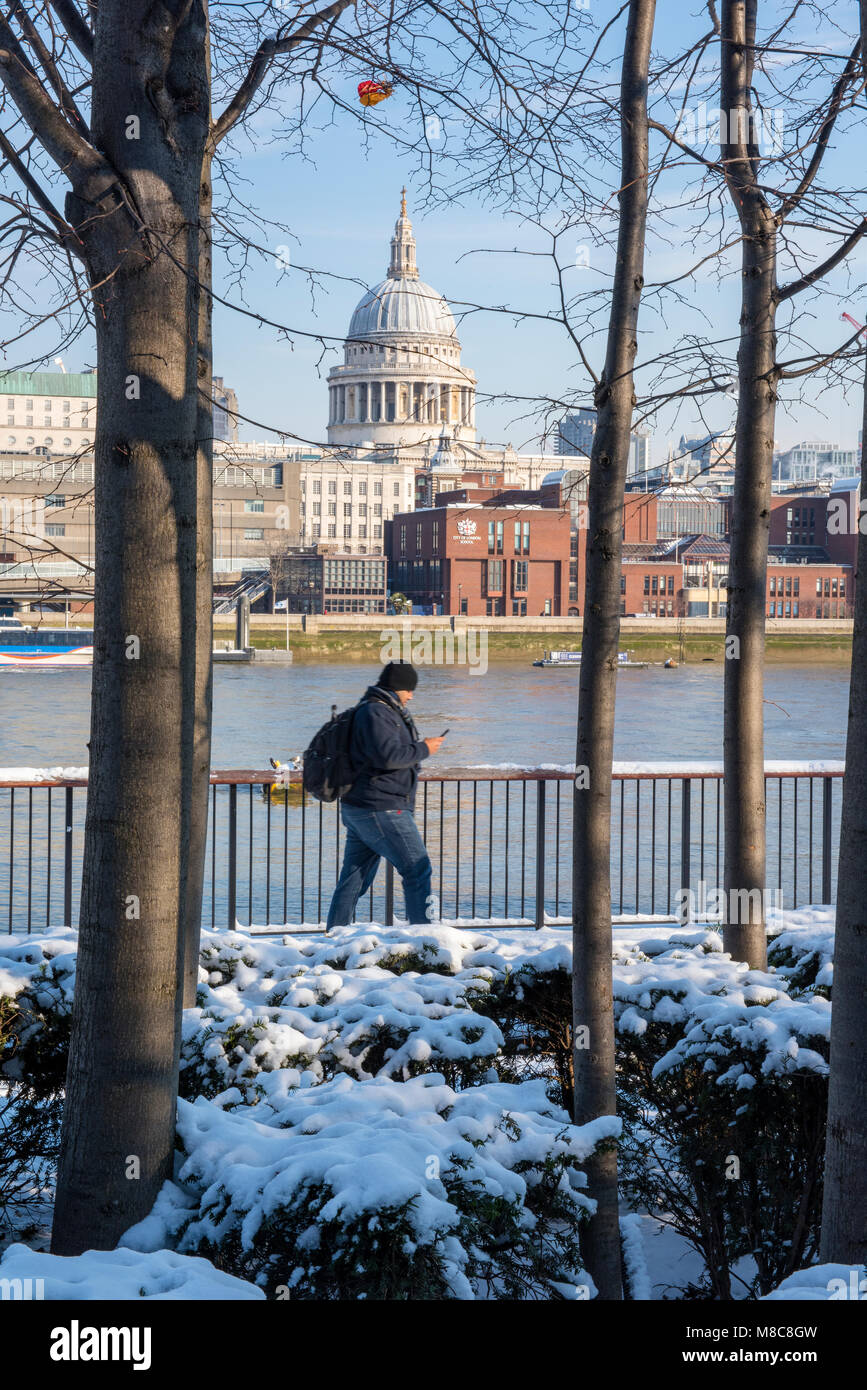 a man walking along the footpath on the thames path or bank of the ...